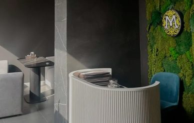 Фитостена из стабилизированного мха с подсвеченным логотипом на ресепшене салона